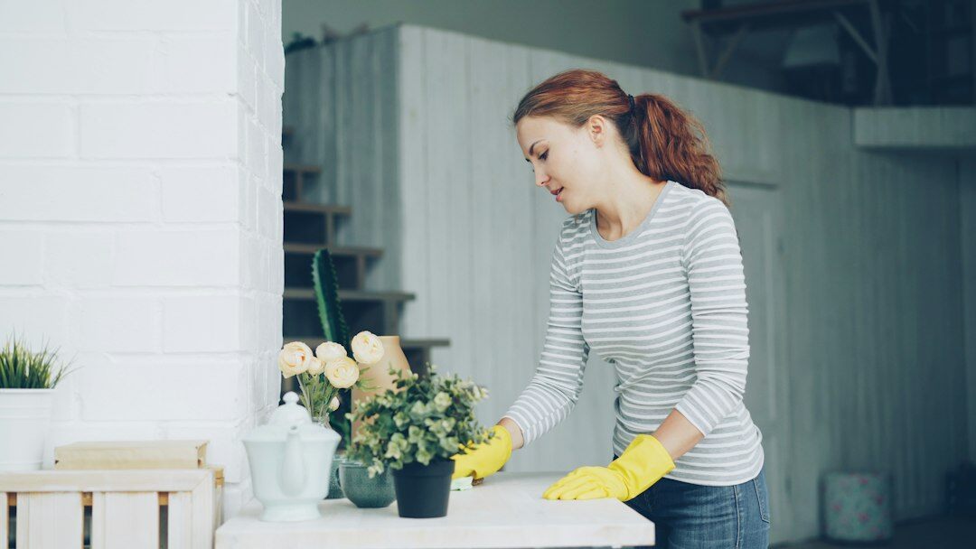 woman dusting furniture